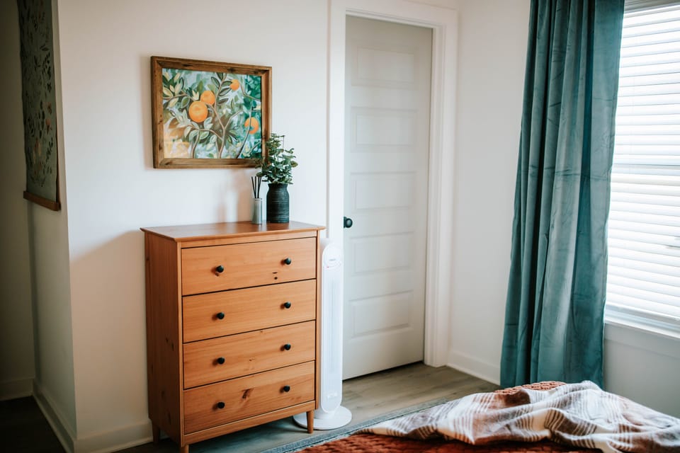 Plenty of dresser space, cozy layers, and calming decor make this bedroom easy to relax in.