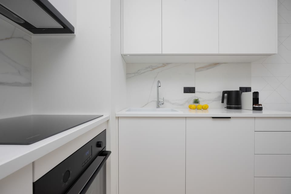 A fully equipped kitchenette with an oven, microwave, and coffee machine. The layout is designed for both practicality and style.