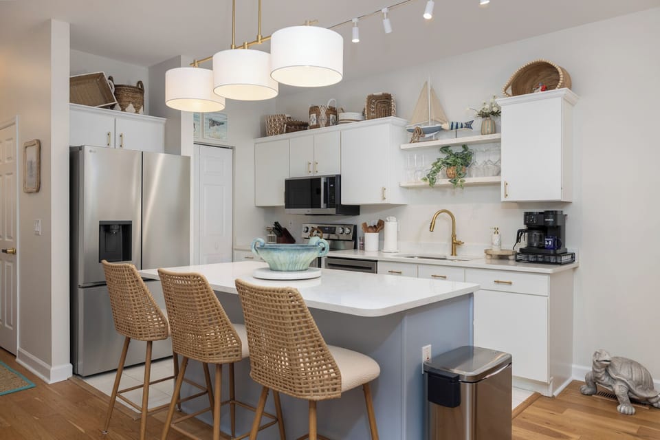 Cook your favorite meals in this bright, modern kitchen featuring stainless steel appliances, marble countertops, and a breakfast bar perfect for morning coffee
