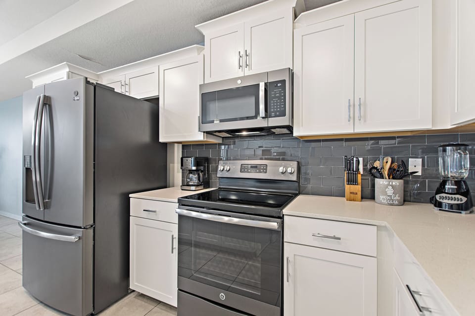 Fully equipped kitchen with stainless steel appliances and dark backsplash – Shine Villas | Sunset Retreat, Storey Lake Resort, Orlando