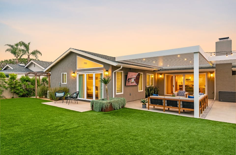 Enjoy a large smart TV and lounge area under a trellis with overhead lighting. 