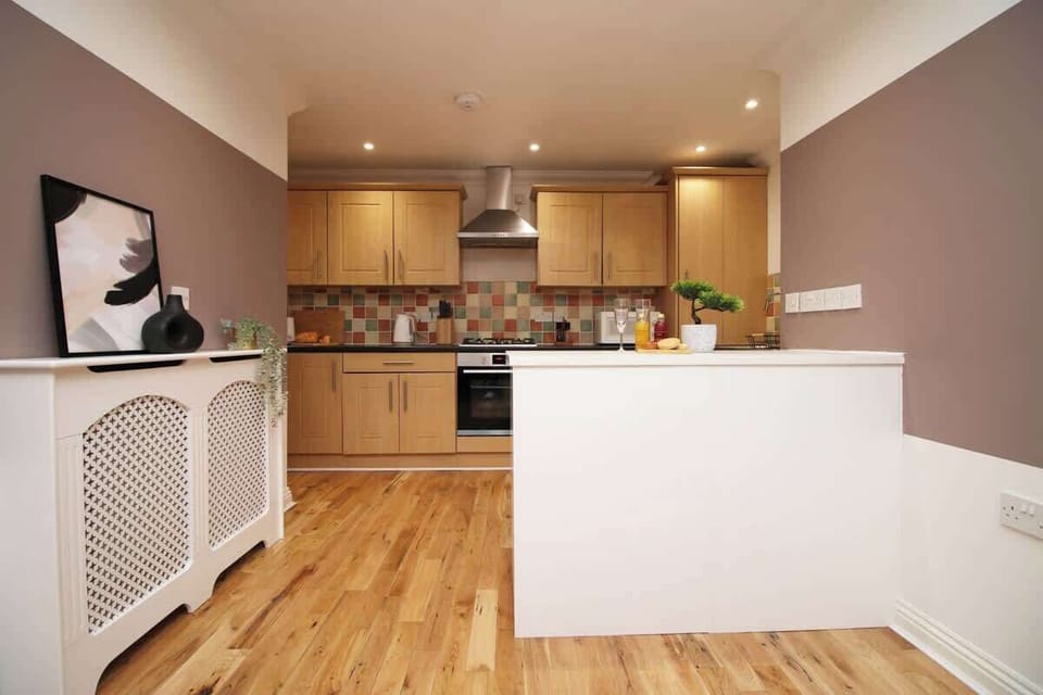 A stylish, fully equipped kitchen featuring modern appliances, spacious worktops and elegant cabinetry. The open layout and warm lighting create a welcoming space, perfect for preparing meals and enjoying a comfortable stay.
