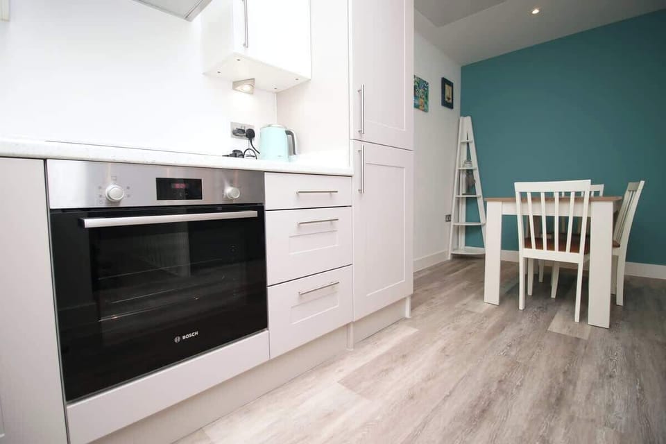 A sleek built-in oven is seamlessly set within contemporary white units, complemented by spacious worktops and elegant finishes, perfect for effortless cooking and entertaining.