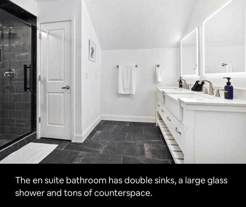 The en suite bathroom has double sinks, a large glass shower and tons of counterspace.