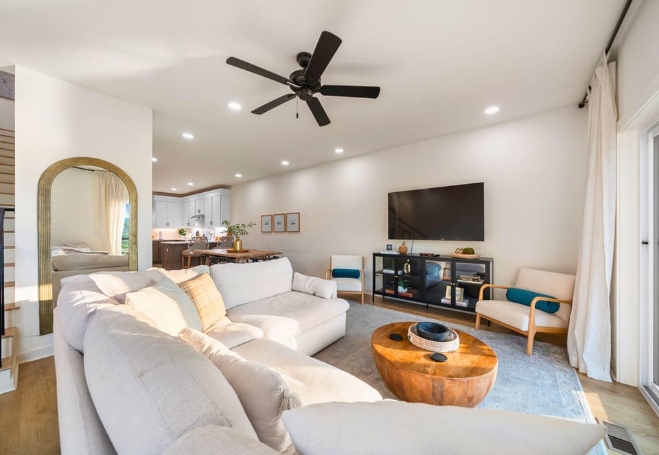Living room with large sectional, smart TV, and open floor plan.