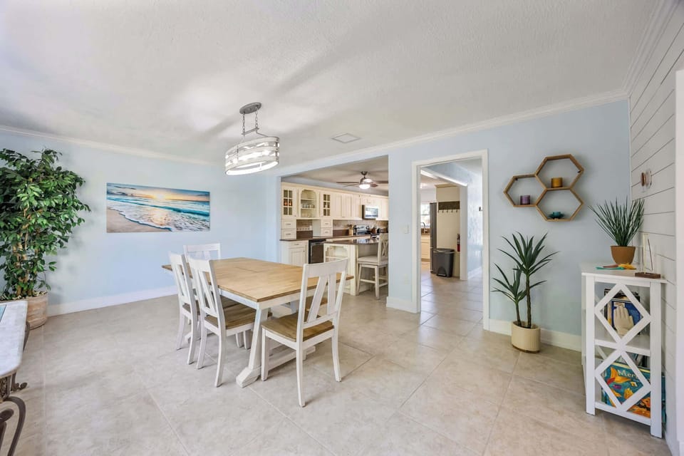 Dining area with natural light and coastal decor connecting to a spacious kitchen