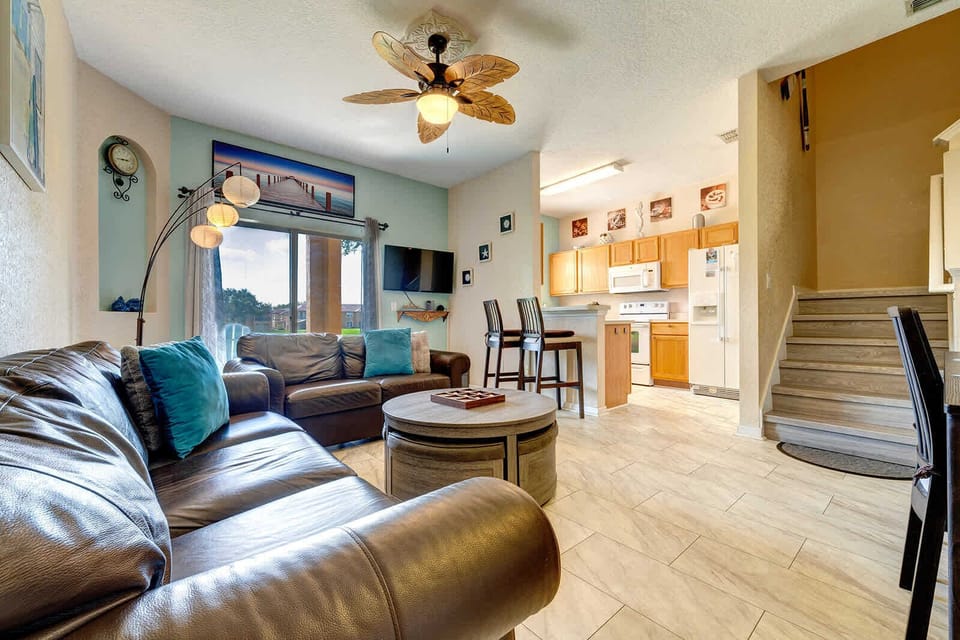 Relax in the cozy living area with leather sofas and a tropical ceiling fan.