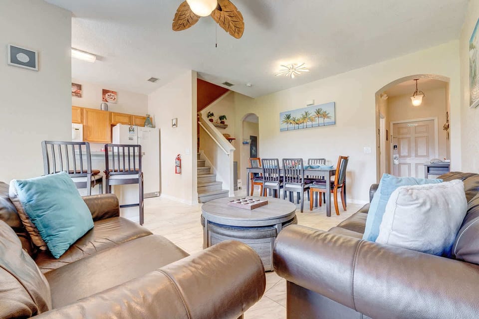 Spacious living and dining area with leather sofas and a modern ceiling fan