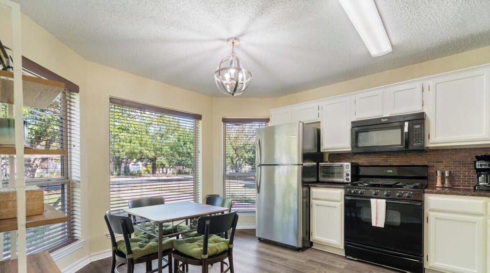 Green cushions, black cabinets, and a chandelier that’s fancier than your dinner plans.