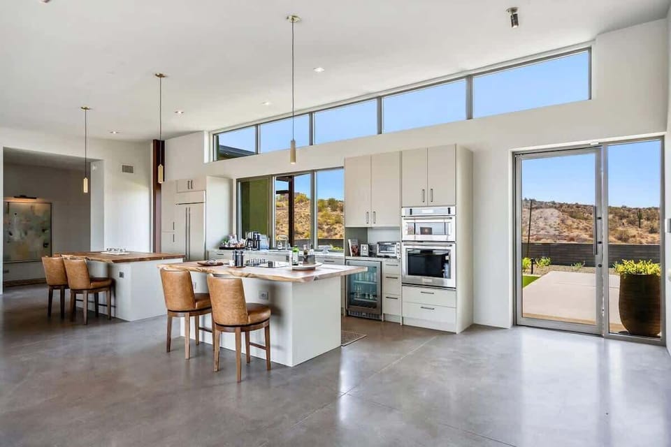 The fully equipped luxury kitchen is stocked with all culinary essentials and features high-end stainless-steel appliances, 2 kitchen islands, 2 breakfast tables, 6 person dining tables, and a wet bar/coffee station.