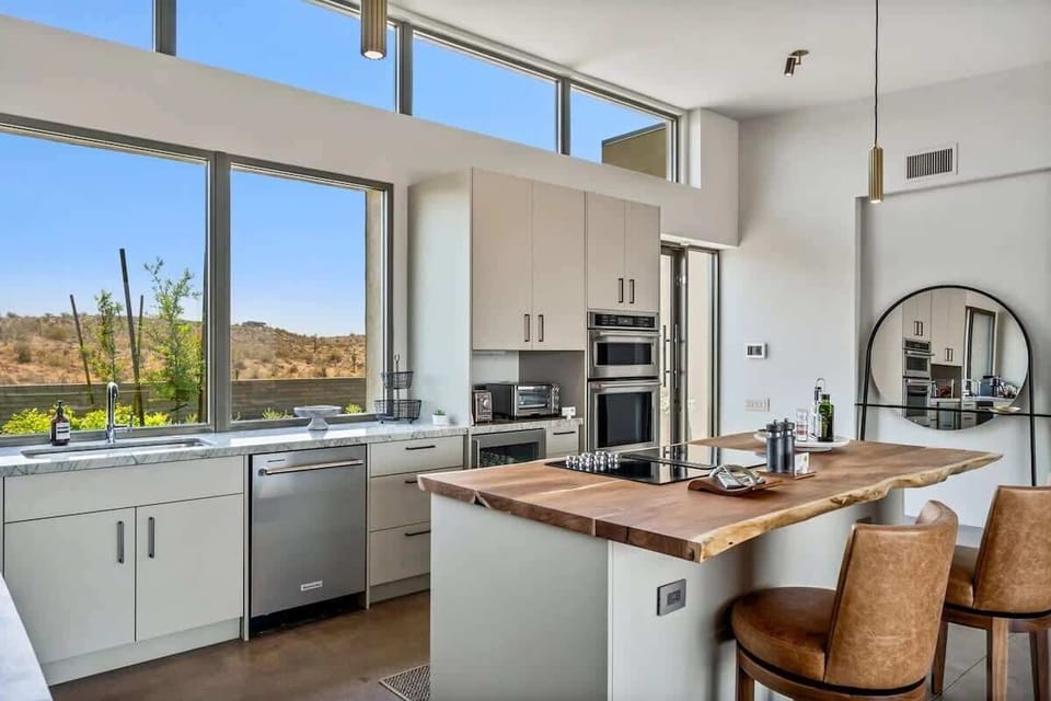 The fully equipped luxury kitchen is stocked with all culinary essentials and features high-end stainless-steel appliances, 2 kitchen islands, 2 breakfast tables, 6 person dining tables, and a wet bar/coffee station.