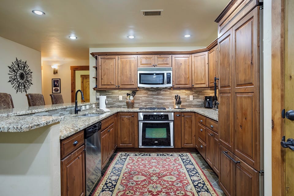 Step into your gourmet kitchen with warm wood cabinets, granite counters, and stainless appliances—perfect for preparing memorable meals.