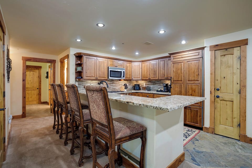 Your spacious kitchen features rich wood cabinets, granite counters, and a breakfast bar where you can gather for meals and conversation.