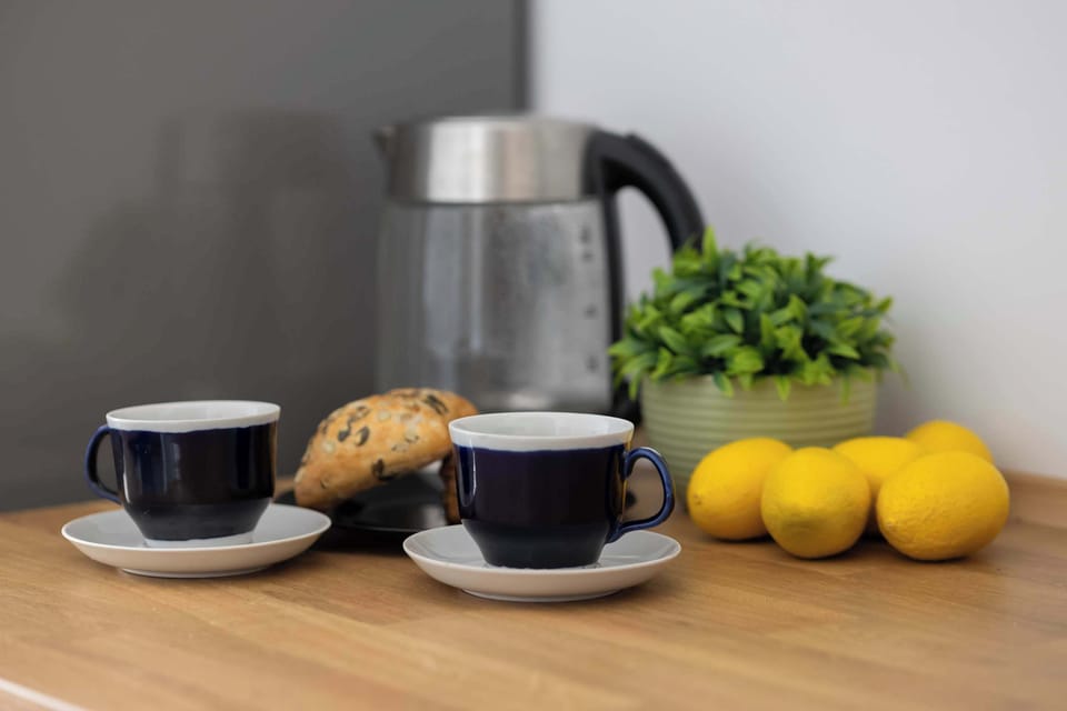A cup of coffee with fresh fruit on the kitchen counter creates the perfect moment for a morning break.