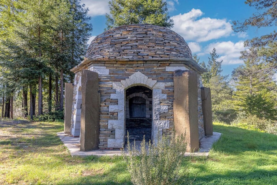 Rustic domed stone pavilion in a redwood clearing—peaceful retreat spot.