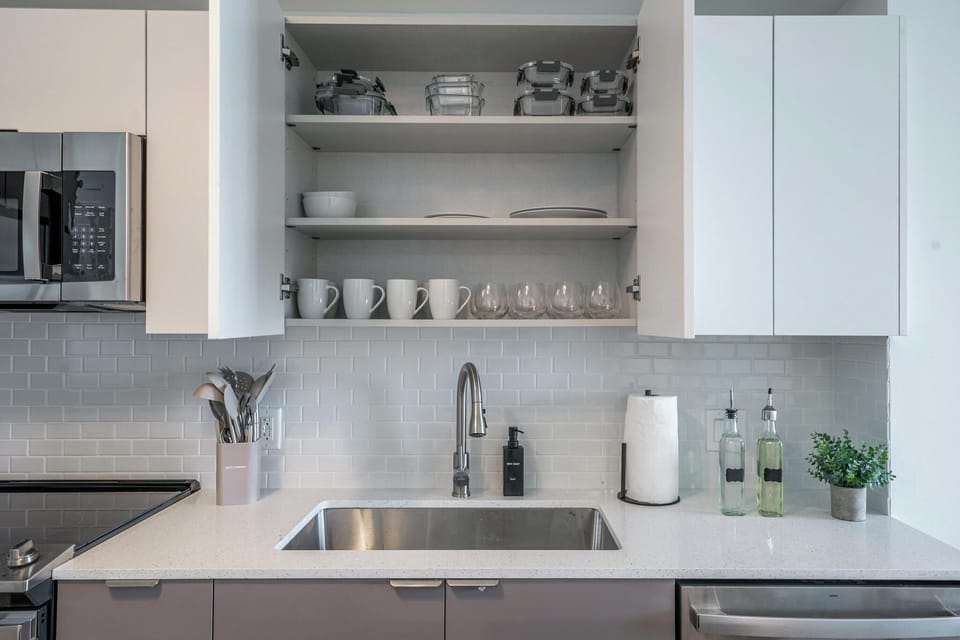 Fully stocked modern kitchen with utensils, cookware, and tableware.
