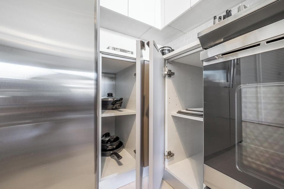 Fully stocked modern kitchen with utensils, cookware, and tableware.