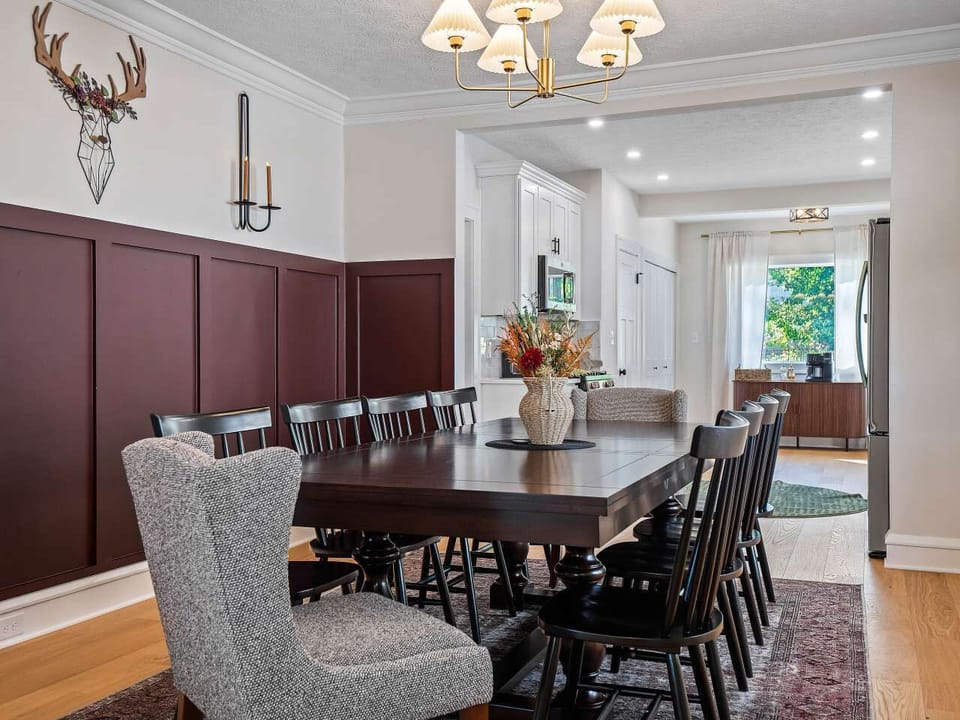 Spacious dining area w/ large table & warm lighting, ideal for shared meals & lively conversation.