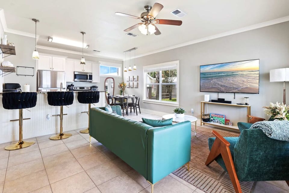 Open concept living space with kitchen island, smart TV, and coastal style