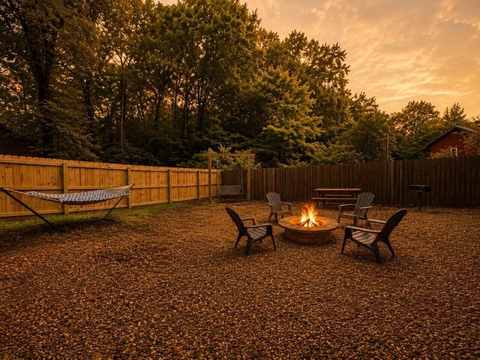 Spacious fenced backyard with fire pit, hammock, swing, and BBQ