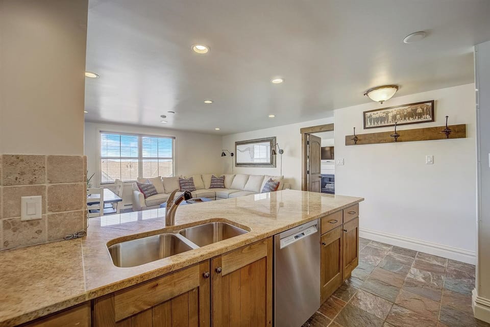 Double sink, dishwasher, and very open kitchen, dining room, living room layout.