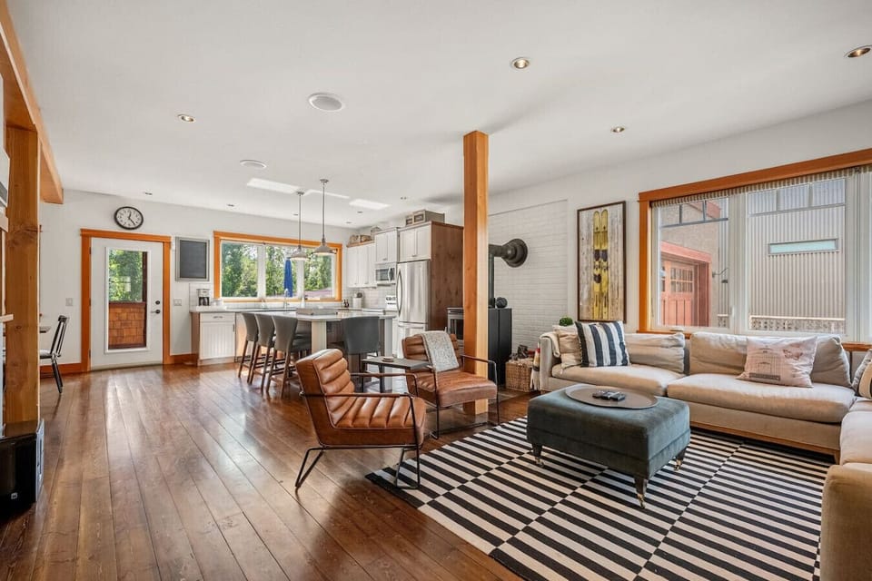 Main floor living room with cozy seating options, a 40` TV with cable, wood-burning fireplace and board games.