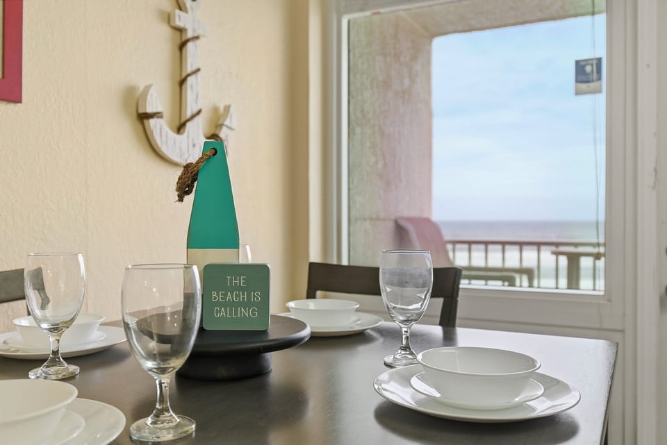 Gather around the table with soothing ocean views just beyond the balcony. Perfect for morning coffee, family meals, or evening conversations, this inviting dining space enhances every relaxing beach stay.