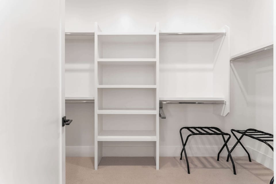 Primary Bathroom featuring 2 single vanities, bathtub, stand-in shower, large walk-in closet, and a bidet.