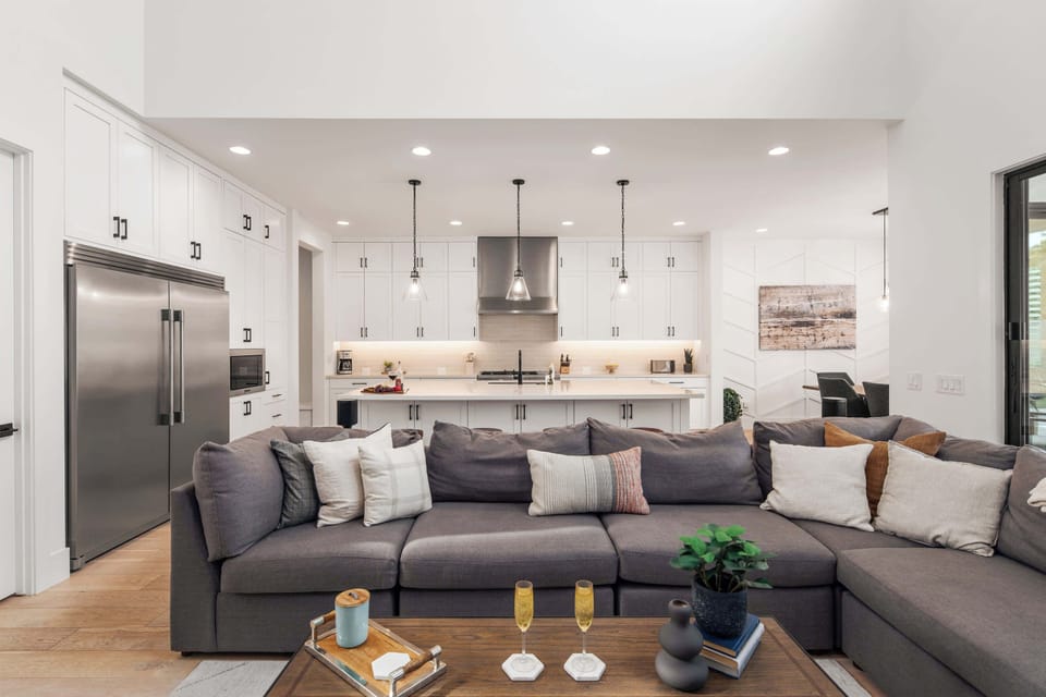 Main living area featuring designer furnishings, Smart TV, fireplace, and access to the backyard.