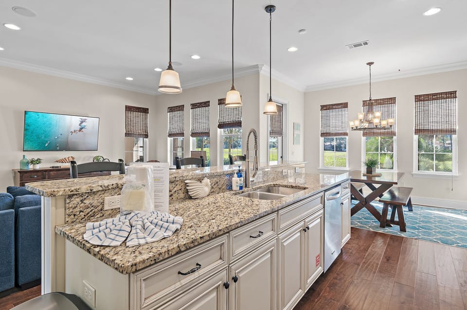 This spacious, light-filled kitchen features expansive granite countertops, stainless steel appliances, and a convenient breakfast bar with seating—perfect for morning coffee or casual meals.