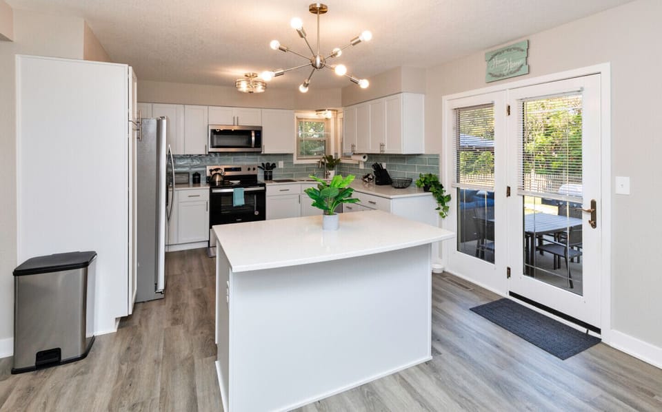 Kitchen w/ island, fridge, stove/oven, microwave, dishwasher and all kitchenware