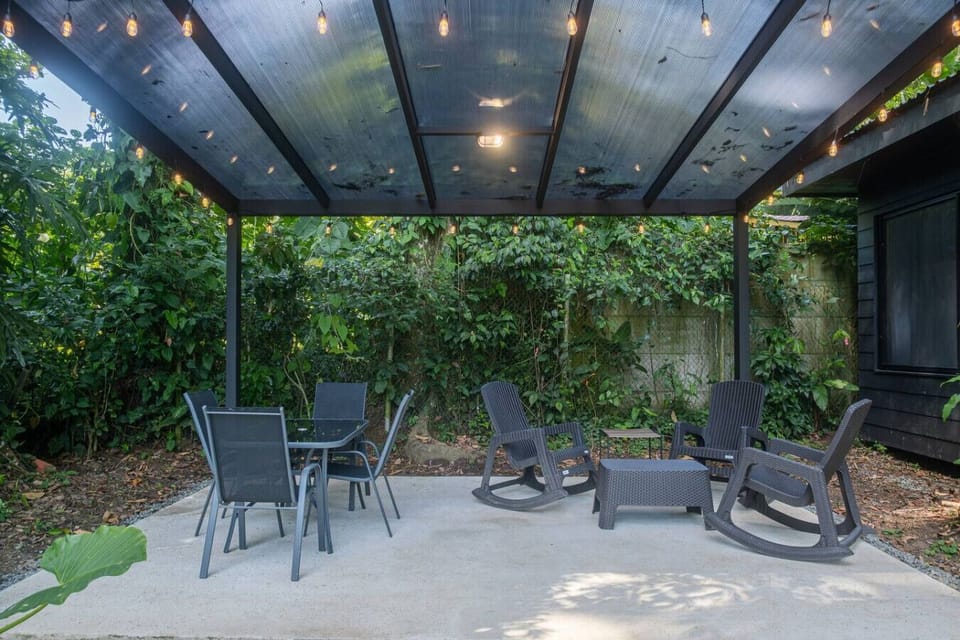 Outdoor patio with pergola and lounge seating at Somnara Botánica, Playa Chiquita, Costa Rica.