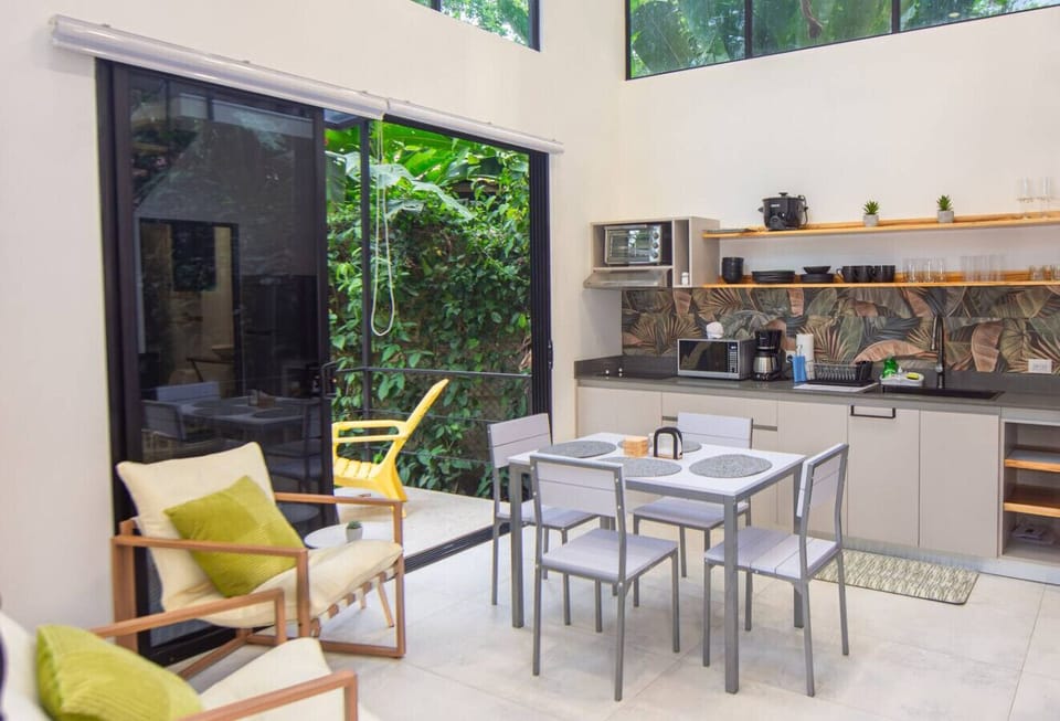 Open-concept kitchen and dining area and lush garden access at Somnara Bosque Tropical, Playa Chiquita, Costa Rica.
