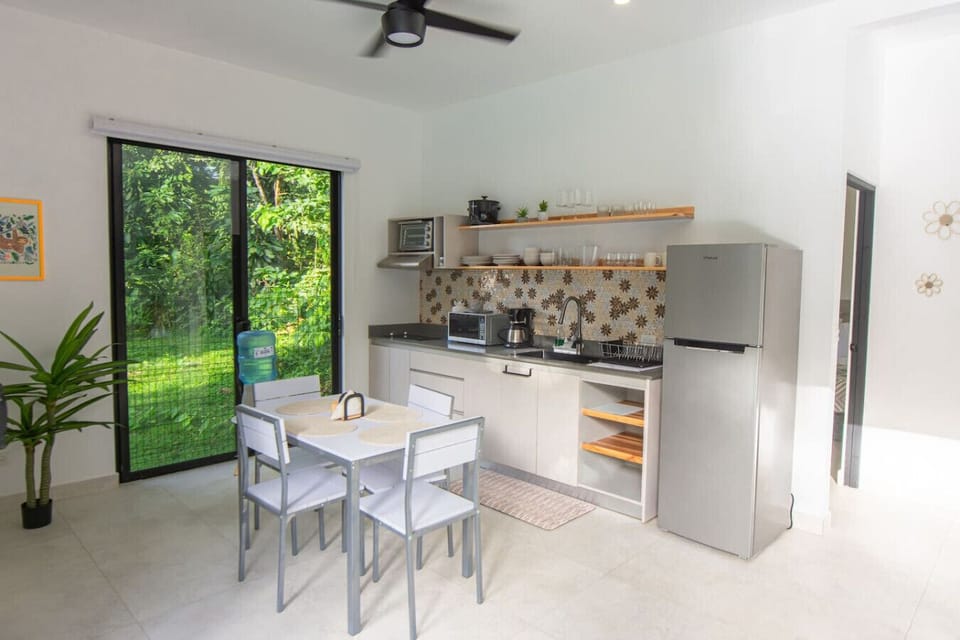 Fully equipped kitchen with dining area, colorful tile backsplash, and garden views, Somnara Villas 4, Playa Chiquita, Costa Rica.