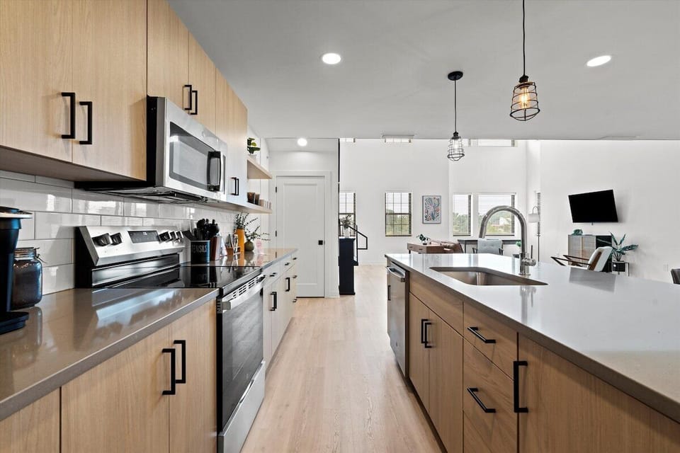 Brand new, modern full kitchen with stainless steel appliances and sleek cabinets—perfect for cooking during your stay in walkable North Kansas City.