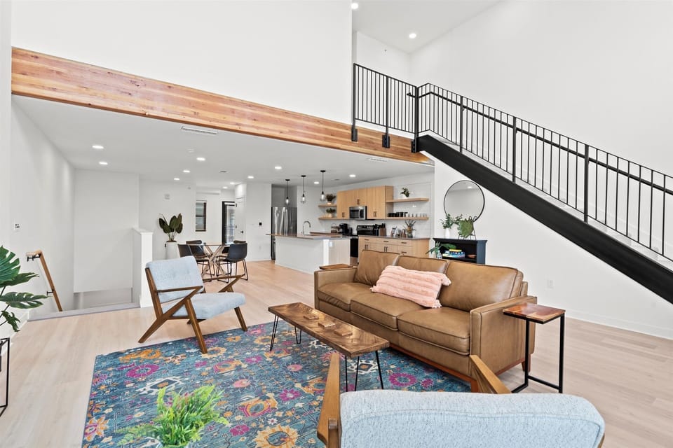 Bright, open-concept living space with mid-century style seating and a smart TV—your perfect home base steps from NKC dining and entertainment.