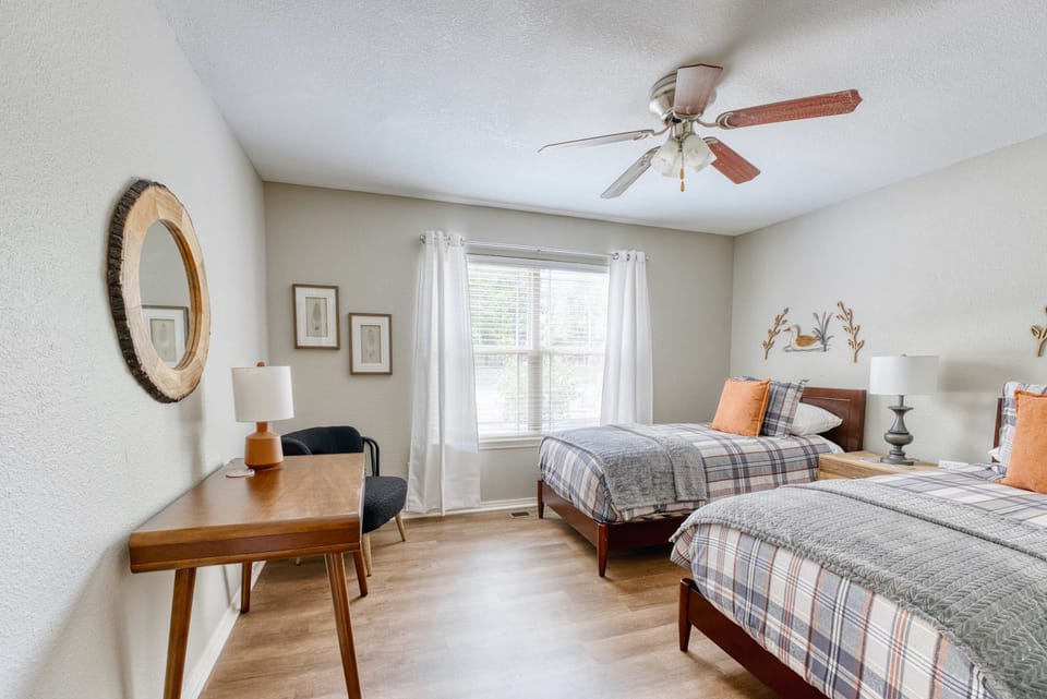 Relax in this roomy retreat featuring two comfortable beds and a ceiling fan for a refreshing stay—ideal for families or group adventures!
