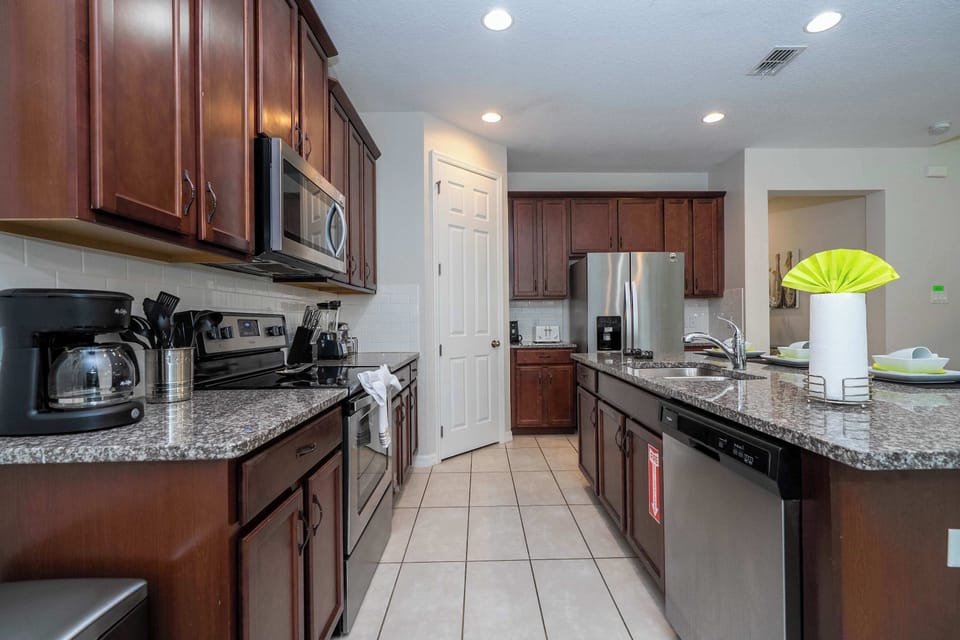Whip up culinary delights in this spacious, modern kitchen with granite countertops, stainless steel appliances, and rich wood cabinetry.
