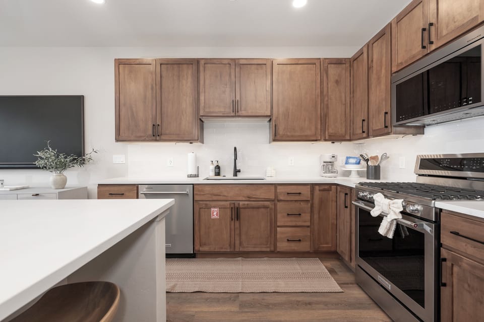 Your modern kitchen features warm wood cabinetry and sleek white countertops, creating the perfect space for cooking memorable meals together.