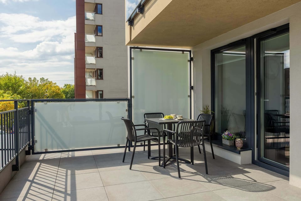 A spacious balcony with outdoor seating lets you enjoy fresh air and morning coffee in a peaceful setting.