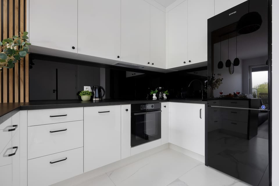 A modern kitchen in a black-and-white design offers an elegant space for cooking, equipped with practical solutions and high-quality appliances.