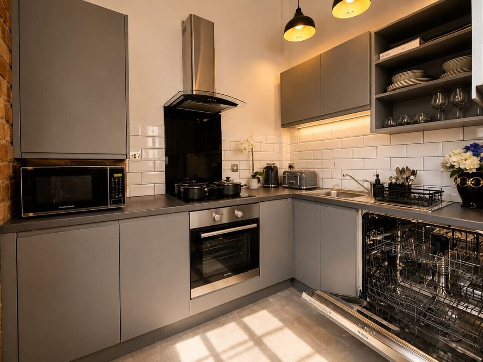 Fully equipped modern kitchen featuring an oven, hob, microwave, dishwasher, kettle, toaster, and all the essentials needed for cooking and dining during your stay.