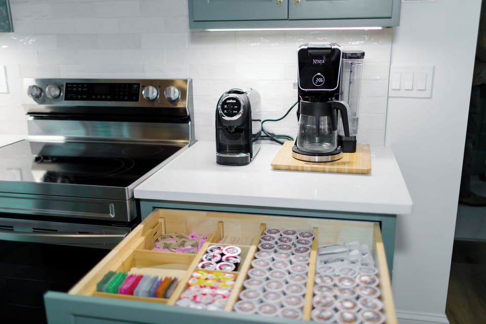 Fully stocked coffee bar with ground coffee, k-cup pods, espresso, tea, hot chocolate and individual creamers