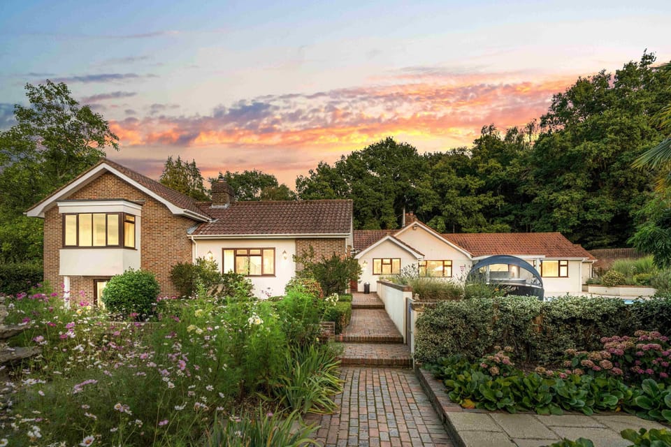 Front view of the stately Churchill Country Retreat, with sweeping driveway and traditional countryside architecture.