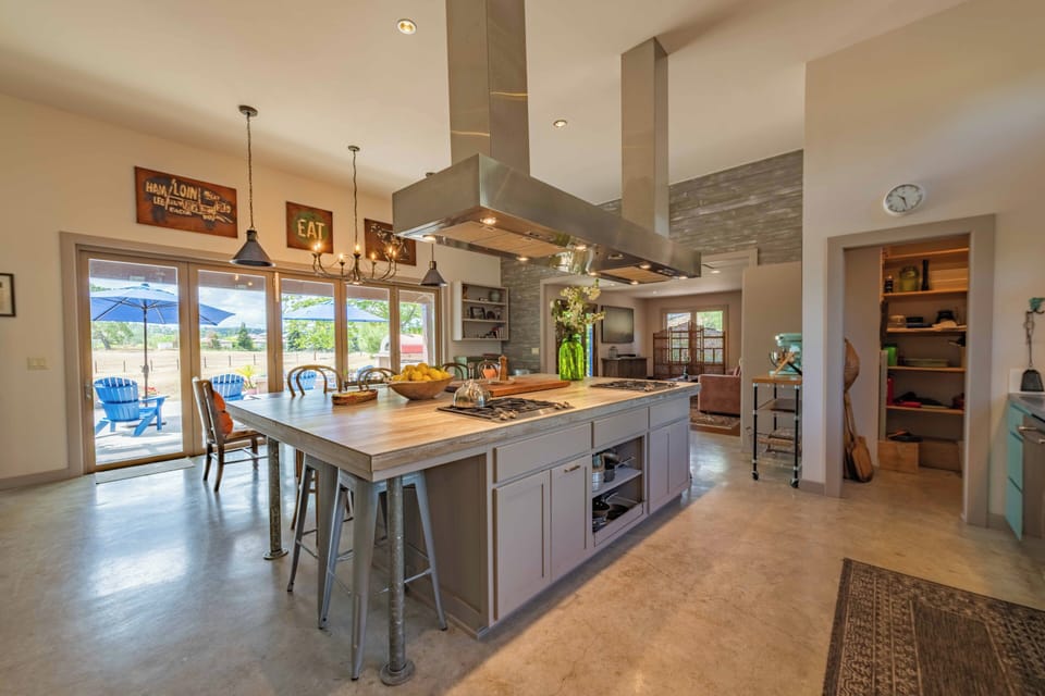 Cook your favorite meals at the spacious island with gas stove while guests relax at the breakfast bar. Large windows fill the chef's kitchen with natural light and mountain views.
