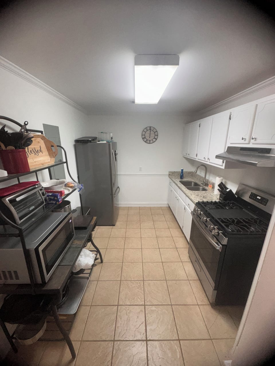 Full kitchen with microwave, stove and refrigerator.