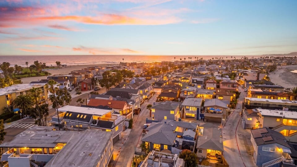 Breathtaking sunset aerial view showcasing your unbeatable location just steps from both the beach and the bay
