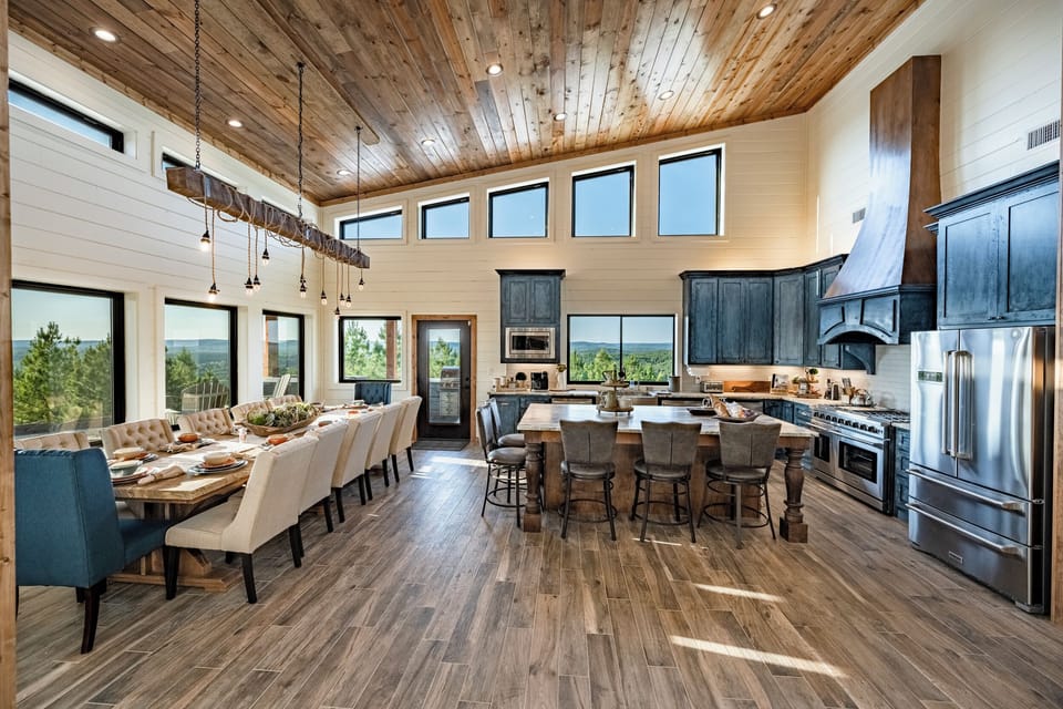 Open-concept kitchen and dining with scenic forest views