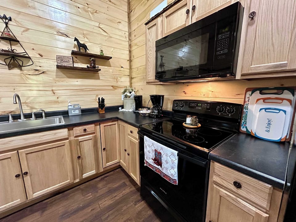Cook with ease—fully stocked with all the essentials, plus two types of coffee makers, stove top, oven, and microwave for hearty home cooked meals.  There is a small dining table plus barstool seating facing the TV to enjoy a meal. 