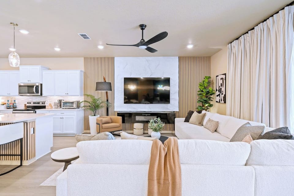 Living room with wall mounted TV, designer slat feature wall and sliders to the pool deck.